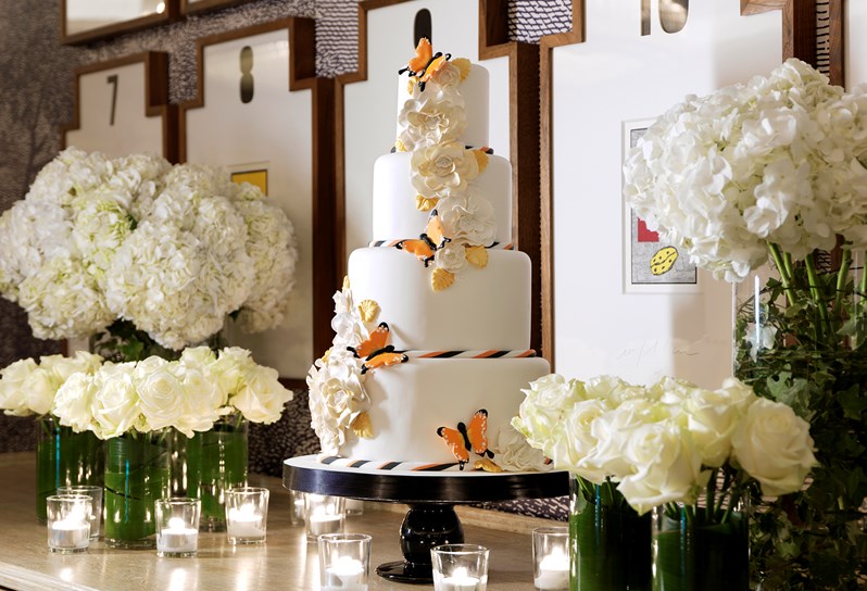 A wedding cake adorned with orange butterflies