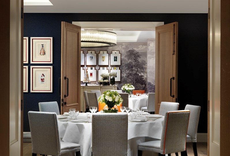 The Sherwood room with large white tables laid up for a formal dinner. In the background double doors open up to the Windmill Room.