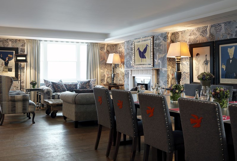 A side view of Nash private room set up in boardroom meeting style with comfortable chairs and a relaxed sitting area.