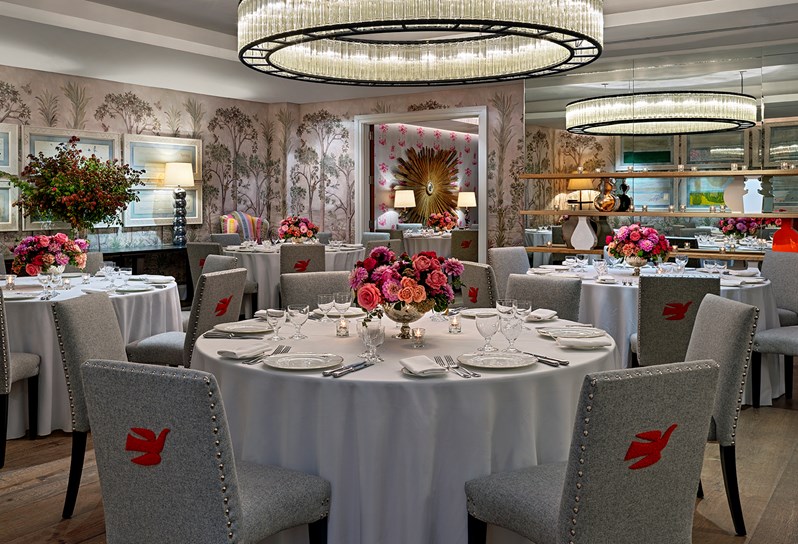 Prince Private event room has walls lined in hand painted mural of trees with beautiful set round banqueting tables and chairs, fresh flowers and spectacular overhead ceiling lights.