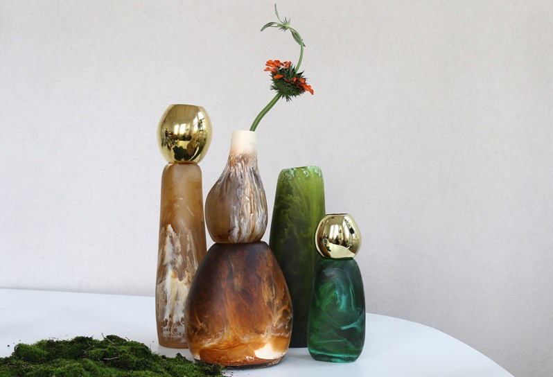 Four quirky, designed vases in various colors and materials.
