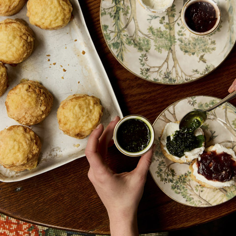 Close up portrait shot of scones with jam and cream, on a table at Brasserie Max
