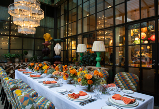 Image of a long table set up for lunch in The Orangery at Crosby Street Hotel.  