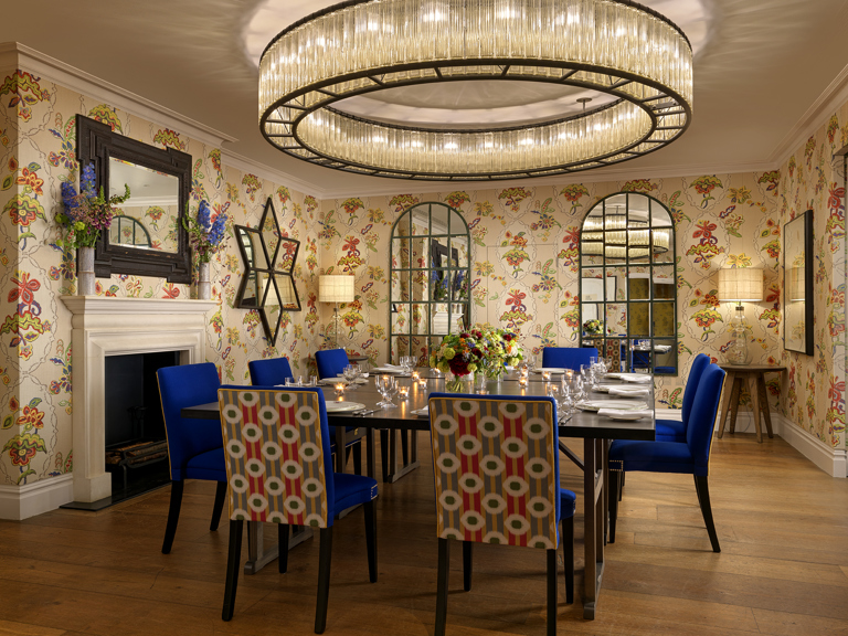 Squared dining table set-up with dim lighting in the Fortune private events room at Covent Garden Hotel