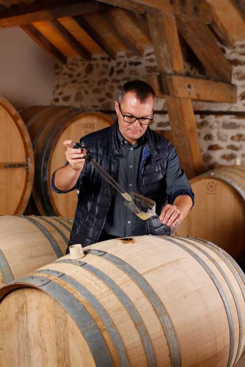 Benoit Dehu samples his Champagne from a wooden barrel