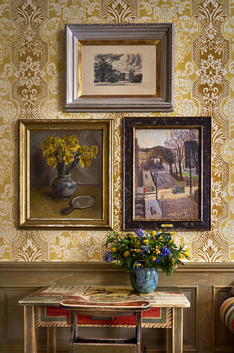 A series of paintings from Bloomsbury Group articles hang against patterned wallpaper at Charlotte Street Hotel in London