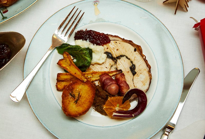 Festive dish with turkey and all the trimmings on Sailor's Farewell crockery. Glass of white wine, salt and pepper shakers and some side dishes in the background