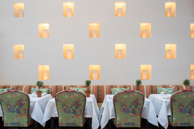 Close up image of dining tables set-up against the wall with art installation in The Orangery private events room at the Whitby Hotel.