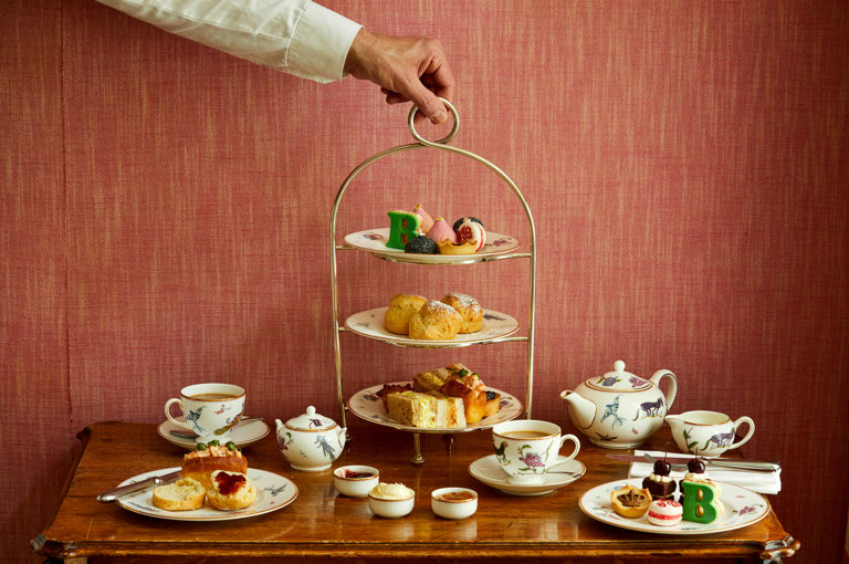 An image of the whole Afternoon Tea Set up with the cakes, sandwiches and cocktails for the Six: The Musical Afternoon Tea at Refuel, Soho Hotel.