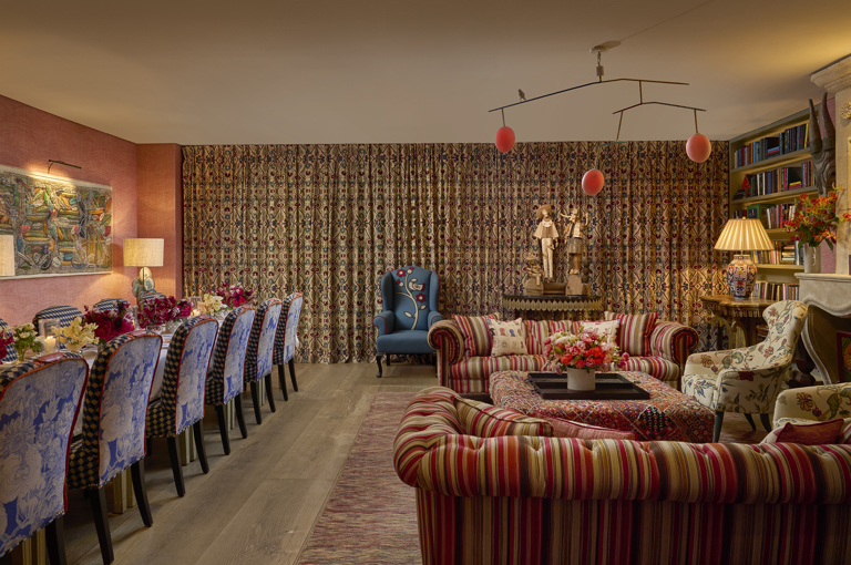 A wide angle shot of the drawing room at Warren Street Hotel set up for private dining: to the left is the dining table set up for twelve and to the right is a relaxed seating area