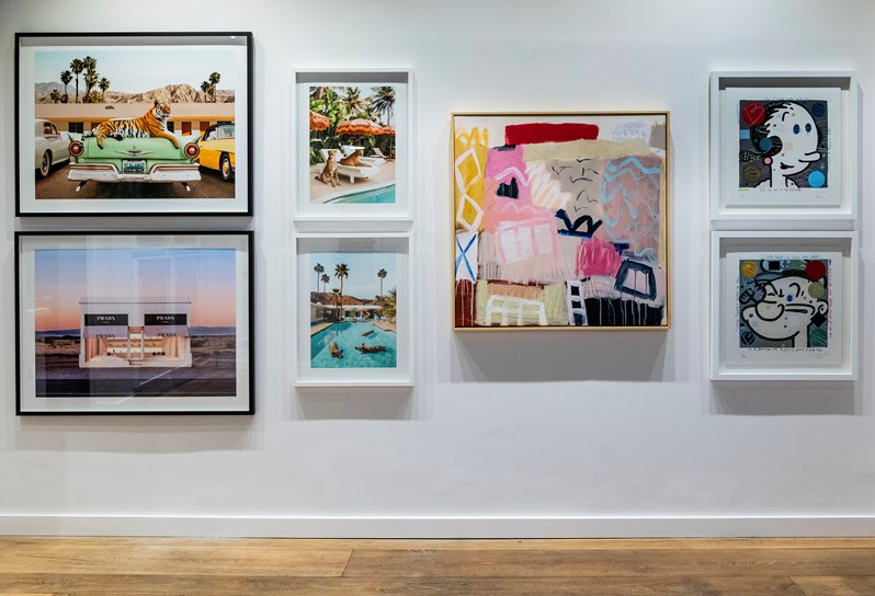 A selection of contemporary paintings hung on a white wall