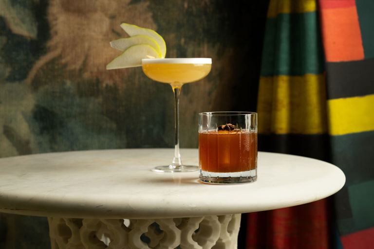 A landscape shot of two of the signature cocktails garnished with apple at Warren Street Bar, Warren Street Hotel