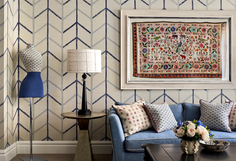 The sofa in a connecting junior suite that has a painting hung above it.