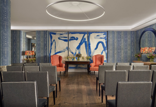 An image of the wedding set in The Indigo Room, a private event room, in The Soho Hotel. With 4 rows of 8 grey chairs across the room, with an aisle down the middle.