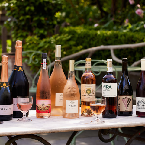 A wide shot of Rose on the Roof at Ham Yard Hotel: there is a selection of bottled rose wines on the table on the terrace