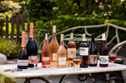 A wide shot of Rose on the Roof at Ham Yard Hotel: there is a selection of bottled rose wines on the table on the terrace