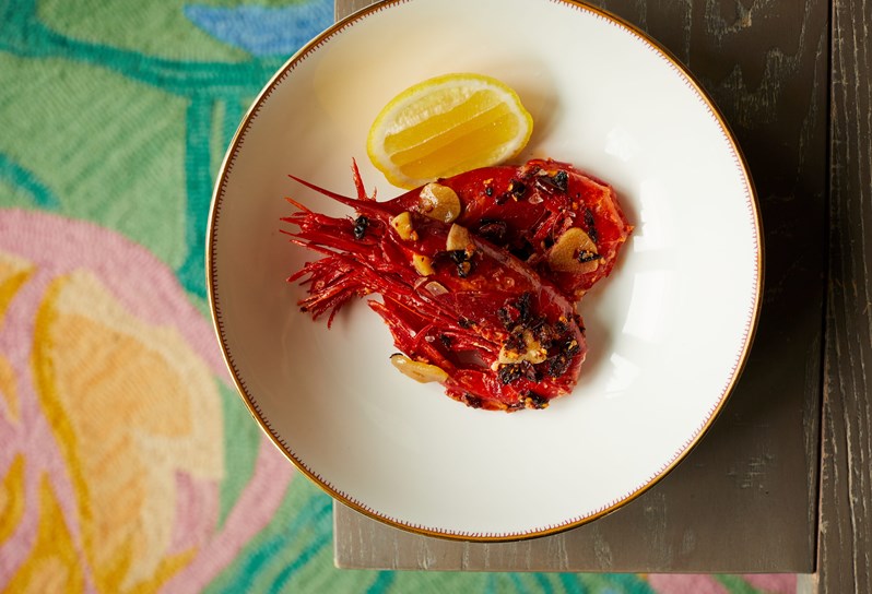A dish of prawns served atop a decorative table cloth