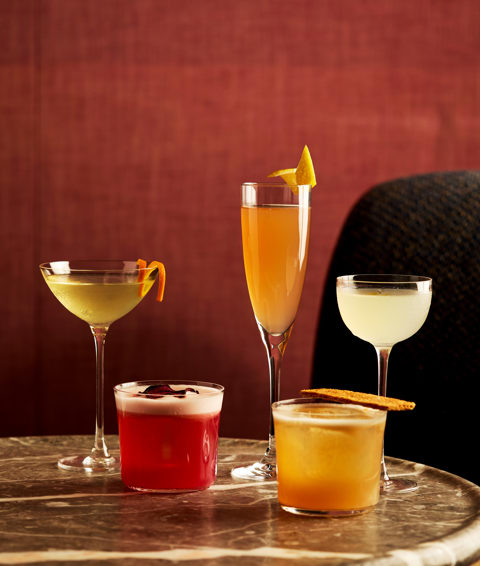 A table of brightly coloured cocktails in different glass styles on a table at Brumus