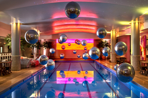The pool at Haymarket Hotel decorated for a party with silver helium baloons floating over the water