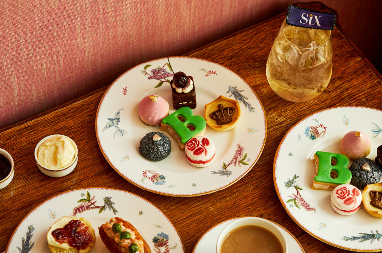 An image of the whole Afternoon Tea Set up with the cakes, sandwiches and cocktails for the Six: The Musical Afternoon Tea at Refuel, Soho Hotel. 