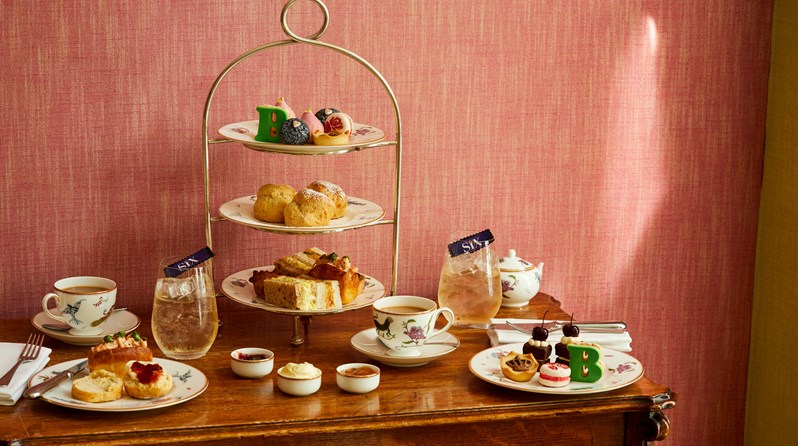 An image of the whole Afternoon Tea Set up with the cakes, sandwiches and cocktails for the Six: The Musical Afternoon Tea at Refuel, Soho Hotel.