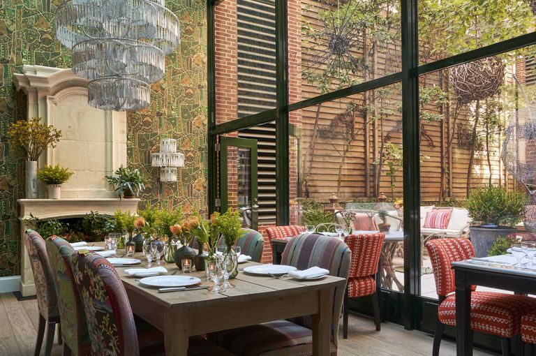 Diagonal shot a long dining table set-up in the Orangery private events rooms at Crosby Street Hotel