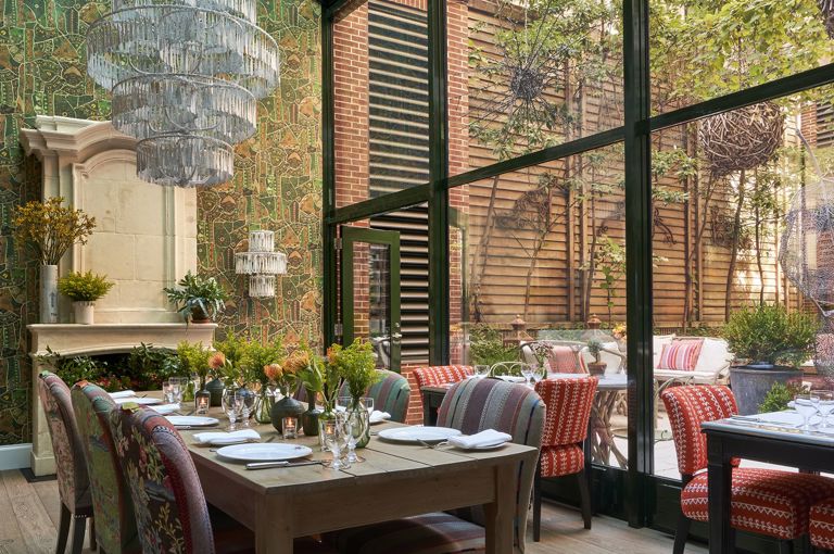 Diagonal shot a long dining table set-up in the Orangery private events rooms at Crosby Street Hotel