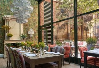 Diagonal shot a long dining table set-up in the Orangery private events rooms at Crosby Street Hotel