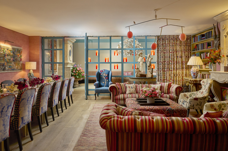 A wide angle shot of the drawing room at Warren Street Hotel set up for private dining: to the left is the dining table set for twelve, and to the right is a relaxed sofa area