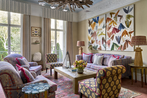 A landscape image of the drawing room at Number Sixteen, focusing on the seating area including sofa and armchairs. 