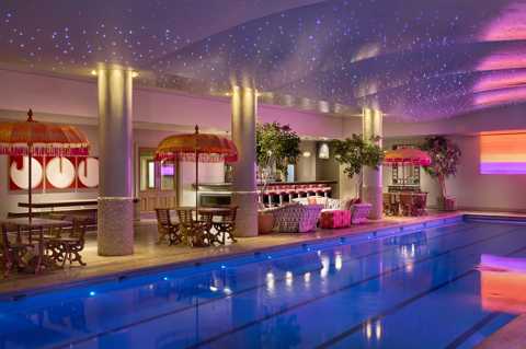 A diagonal shot of the swimming pool and bar at Haymarket Hotel looking across to the pool bar area