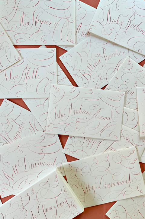 A collection of envelopes with names written in red by calligrapher Stephanie Fishwick