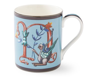 The gold "N" on this pale blue mug forms a decorative background to the mythical winged creature, with its blue and yellow corn-like floral posy.