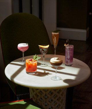 An image of multiple cocktails on a table in The Crosby Bar.
