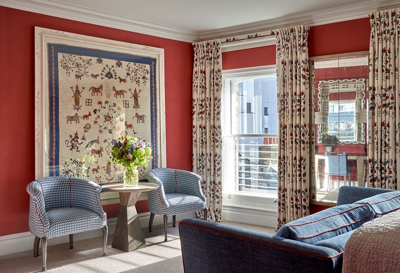 A lounge area centered there are 2 armchairs either side with a table in the middle and a sofa facing these.