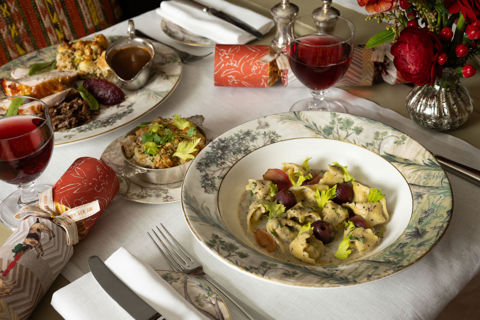 This image shows a festive dining scene at the Warren Street Bar, Warren Street Hotel, featuring a seasonal pasta dish and a traditional roast dinner served on Tall Tress Fine Bone China.