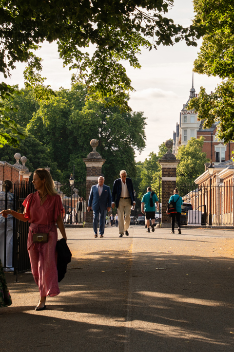 A shot looking through the gates of Royal Hospital Chelsea, where Treasure House Fair takes place. It is a sunny day and people can be seen walking through in smart clothing in groups