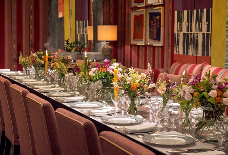 An image of the long dining table set up with flowers in the Sherwood private events room, at The Ham Yard Hotel.