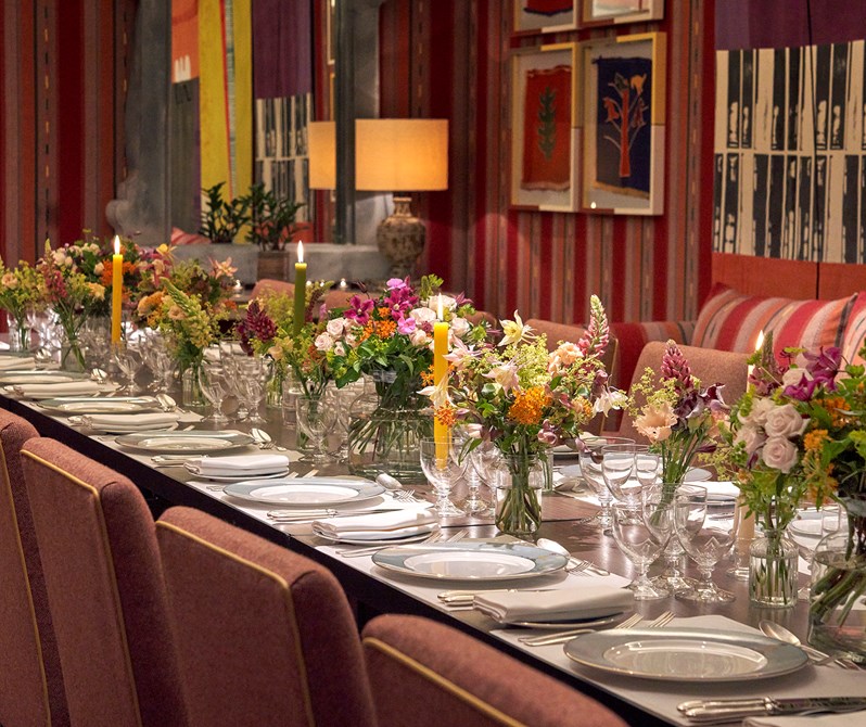 An image of the long dining table set up with flowers in the Sherwood private events room, at The Ham Yard Hotel.
