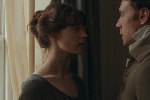 A still from the film 'Sense and Sensibility'. A close up of a man and woman standing closely facing one another