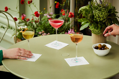 Wide shot of cocktails, bar snacks and guests on the terrace at Oscar