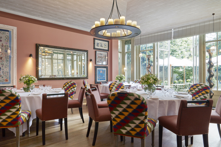Wide shot of round dining tables in the Orangery at Number Sixteen