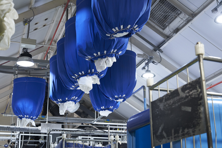 Bags of laundry are hung from the ceiling at Palace Laundry