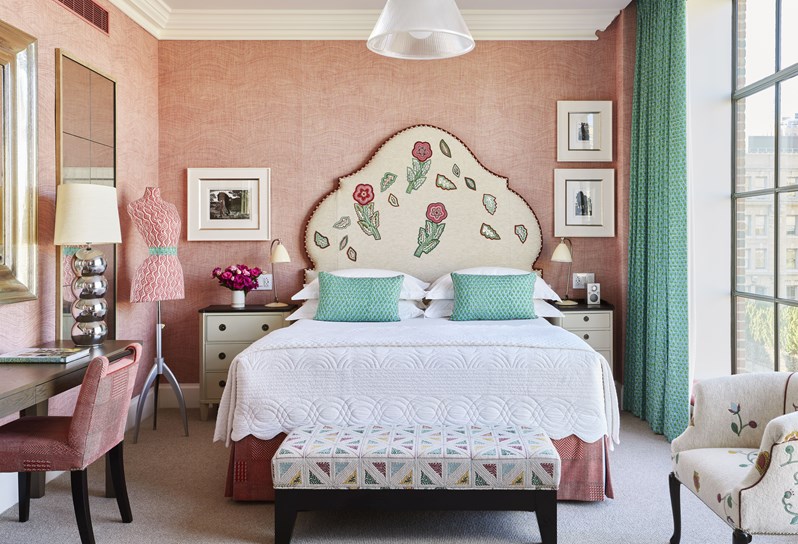 A pink themed hotel room with a cream floral applique headboard at Crosby Street Hotel, New York