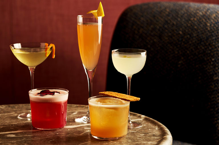 A table of festive cocktails in different glass styles on a table at Brumus
