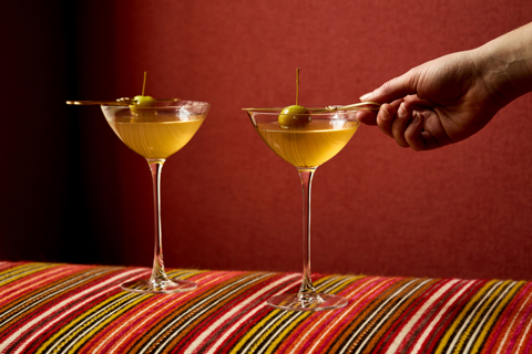 An image of two vodka based martini cocktails, sitting on stripy furniture. 