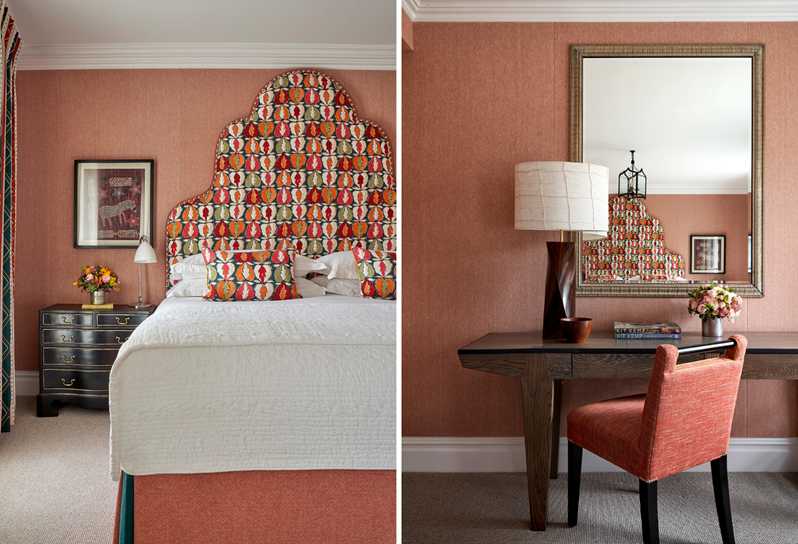 An image red themed room at Charlotte Street Hotel with an orange, red and green leaf patterned headboard with matching cushions next to a red chair and wooden desk with a mirror hanging above the desk