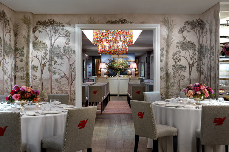 Round dining tables set-up in the Prince private events room looking over a wedding set up in the Spring room at Crosby Street Hotel