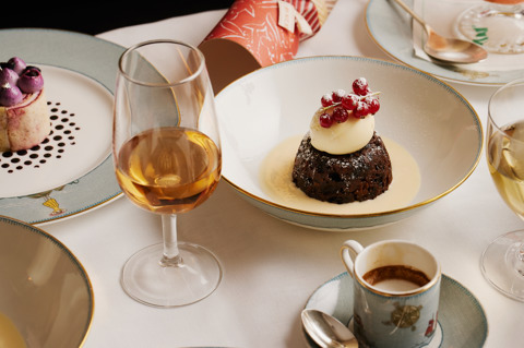 This image shows a close up image of the Ham Yard Christmas pudding, brandy sauce and brandy butter and the Chestnut and blackberry rouladeon Sailors Fairwell crockery. This is to promote the Christmas Day Menu at Ham Yard Hotel. 