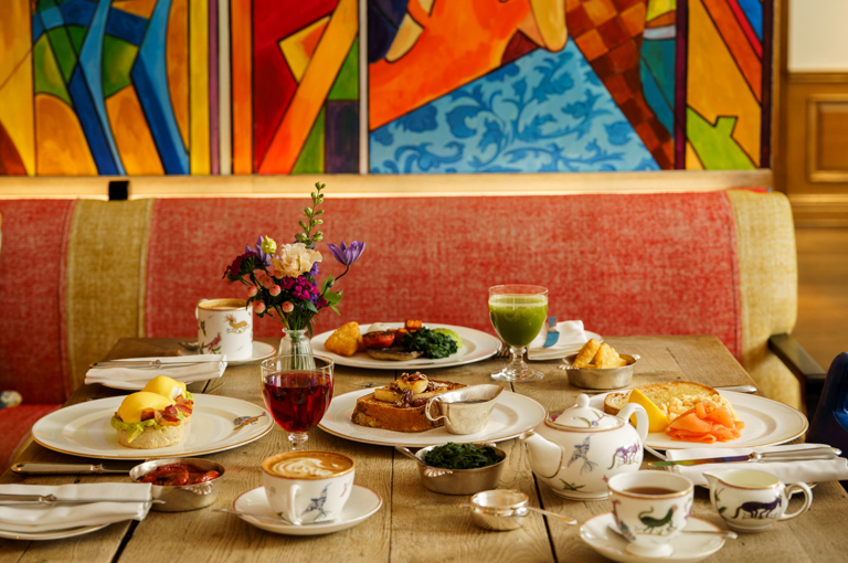 An image of multiple dishes from the breakfast menu including the Brioche French toast with caramelised banana, pecans and maple syrup and Oscar Benedict with crispy bacon and crushed avocado at Oscar, Charlotte Street Hotel.